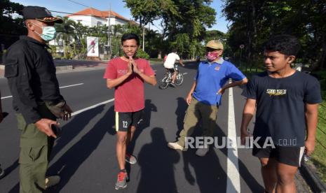 Anggota Satpol PP Provinsi Bali menegur warga yang tidak menggunakan masker saat inspeksi mendadak di kawasan Monumen Bajra Sandhi Renon, Denpasar, Bali, Ahad (19/4/2020). Inspeksi di kawasan ruang publik tersebut untuk mengedukasi dan memberikan pemahaman kepada masyarakat agar muncul kesadaran untuk ikut mengurangi risiko penularan COVID-19