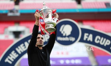 Manajer Arsenal Mikel Arteta merayakan dengan trofi setelah memenangkan Piala FA, ketika permainan dilanjutkan di balik pintu tertutup setelah wabah penyakit coronavirus ( COVID-19)