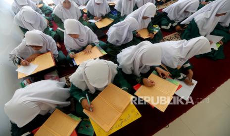  Pelajar muslim Indonesia menulis saat mereka menghadiri ruang kelas di Pondok Pesantren Sirajussa