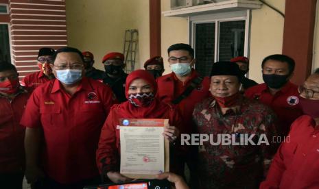 Ketua DPD PDI Perjuangan Lampung Sudin (kedua kanan) mendampingi bakal calon Wali Kota Bandar Lampung Eva Dwiana (tengah) didampingi calon Wakil Wali Kota Bandar Lampung Dedi Amrullah (kedua kanan) saat menunjukkan surat rekomendasi dari DPP PDI Perjuangan di Kantor DPD PDI Perjuangan Lampung, Lampung, Selasa (11/8/2020). DPP PDI Perjuangan resmi memberikan rekomendasi dan mengusung pasangan Eva Dwiana dan Dedi Amrullah sebagai pasangan bakal calon Wali Kota dan Wakil Wali Kota Bandar Lampung tahun 2020. 