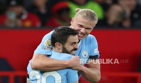  Erling Haaland memeluk Bernardo Silva saat menghancaurkan MU 3-0, Senin (30/10/2023). 