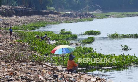 Aktivitas warga dipinggiran Sungai Citarum yang dipenuhi eceng gondok di Cihampelas, Kecamatan Cililin, Kabupaten Bandung Barat. Tak hanya sampah, keberadaan tumbuhan eceng gondok menjadi salah satu penyebab terhambatnya aliran sungai dan pemicu pendangkalan sungai serta waduk dari aliran Citarum.