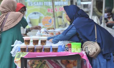 Penjual makanan untuk berbuka puasa (takjil) merapikan dagangannya di kawasan Talang Kelapa, Palembang, Sumatera Selatan, Jumat (24/4/2020). Memasuki bulan suci Ramadhan, penjual takjil musiman bermunculan dan menawarkan aneka makanan