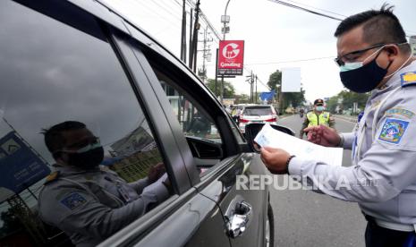 Petugas gabungan satgas Covid-19 DIY memeriksa surat keterangan tes cepat atau swab di Tempel, Sleman, Yogyakarta, Jumat (12/2). Pemeriksaan surat keterangan bebas Covid-19 ini dilakukan di tiga titik perbatasan Yogyakarta. Hal ini dilakukan untuk meminimalkan potensi penyebaran Covid-19 sat libur panjang Imlek.