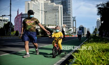 Anak bersama orangtuanya saat bersepeda di kawasan Bundaran Hotel Indonesia, Jakarta. etua Bidang Perubahan Perilaku Satgas COVID-19 Sonny Harry Harmadi mengimbau orang tua agar membiasakan anak melakukan protokol kesehatan selama bepergian. Hal tersebut guna menghindari penyebaran COVID-19 di masa libur Natal dan Tahun Bari, yang mana anak-anak dapat menjadi superspreader karena memiliki tarikan napas yang lebih cepat.