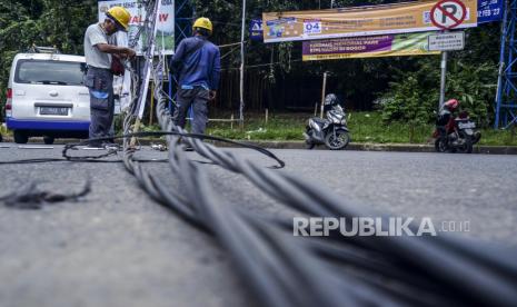 Petugas PLN memperbaiki jaringan kabel listrik yang menjuntai ke jalan di Jalan Pemuda, Kota Bogor, Jawa Barat, Jumat (27/1/2023). Pemerintah memastikan tidak ada kenaikan tarif listrik untuk 13 golongan bersubsidi. 