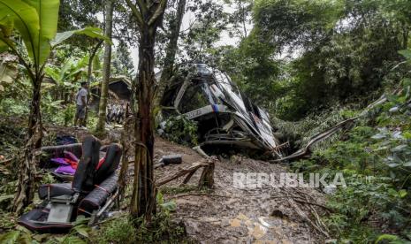  Warga memeriksa bangkai bus yang jatuh ke jurang di Sumedang Jawa Barat, Kamis 11 Maret 2021. Bus wisata yang membawa rombongan siswa SMP, guru, dan orang tua siswa itu terjun ke ketinggian 20 meter (65 kaki). jurang yang dalam setelah remnya tampaknya tidak berfungsi, menewaskan sejumlah orang, kata polisi dan penyelamat.