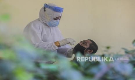 Tenaga kesehatan melakukan tes usap antigen kepada warga