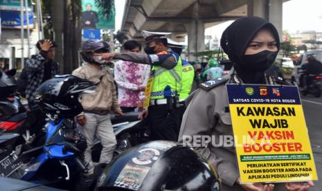 Sejumlah personel Polresta Bogor Kota melakukan razia vaksinasi booster bagi pengendara motor di jalan KH Sholeh Iskandar, Kota Bogor, Jawa Barat, Kamis (28/7/2022). Razia vaksinasi booster tersebut sebagai upaya pencegahan penyebaran virus penyebaran COVID-19 yang mulai menikat kembali. 