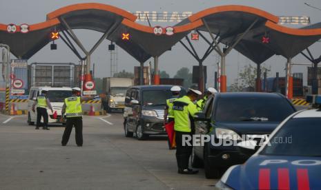 Petugas Kepolisian memeriksa kelengkapan dokumen perjalanan saat penyekatan mudik lebaran 2021 di Gerbang Tol Palimanan, Jawa Barat, Sabtu (8/5). Pada hari ketiga diberlakukannya larangan mudik lebaran, kendaraan penumpang yang tidak dilengkapi dokumen perjalanan lengkap diputarbalikkan oleh petugas di Gerbang Tol Palimanan. Foto : Edwin Putranto/Republika