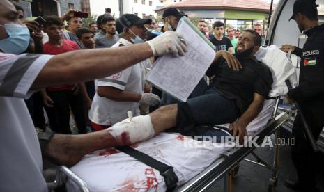 Petugas medis memindahkan seorang pemuda yang terluka, yang ditembak oleh pasukan Israel di kakinya saat protes di perbatasan Jalur Gaza dengan Israel, ke ruang perawatan rumah sakit Shifa di Kota Gaza, Sabtu, 21 Agustus 2021.