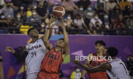 Pebasket putra Bali Ida Bagus Arghantara (kedua kiri) berebut bola dengan pebasket putra Papua Armando Kaize (kiri) pada pertandingan basket putra 5x5 PON XX Papua di Gor Mimika Sport Complex, Rabu (29/9/2021). 