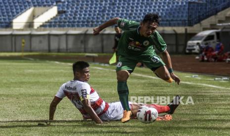 Penyerang PSS Sleman Derry Rachman (kanan) dijegal pemain Madura United dalam pertandingan babak penyisihan Grup C Piala Menpora 2021 di Stadion Si Jalak Harupat, Kabupaten Bandung, Selasa (23/3). Dalam pertandingan tersebut Madura United mengalahkan PSS Sleman dengan Skor 2-1. Foto: Republika/Abdan Syakura