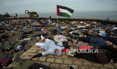 Demonstran pro-Palestina berbaring di tanah saat memprotes serangan Israel di Gaza, di San Sebastian, Spanyol utara, Ahad (17/3/2024). Ratusan pengunjuk rasa di San Sebastian Spanyol berbaring bersama di tanah untuk memberikan penghormatan kepada para korban perang Israel di Gaza.