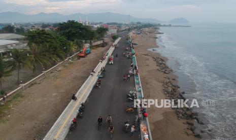 Foto udara sejumlah warga dan pedagang memanfaatkan jembatan penghubung pantai untuk berwisata, di Pantai Lolong, Padang, Sumatera Barat, Selasa (2/6). Juru Bicara Gugus Tugas Penanganan Covid-19 Sumatera Barat Jasman Rizal mengatakan kini sudah ada 6 kabupaten dan kota di Sumbar yang kembali mencatatkan nol kasus positif covid-19 atau kembali menjadi zona hijau. 