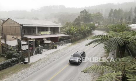 Sebuah mobil melaju di jalan yang tertutup abu vulkanik dari letusan Gunung Sinabung, di Karo, Sumatera Utara, Indonesia, Senin, 10 Agustus 2020. Gunung berapi yang bergemuruh itu meletus Senin, mengirimkan kolom material vulkanik beberapa ribu meter ke dalam. langit. Sinabung adalah satu di antara lebih dari 120 gunung berapi aktif di Indonesia yang rawan terjadi pergolakan seismik karena lokasinya di Pasifik.