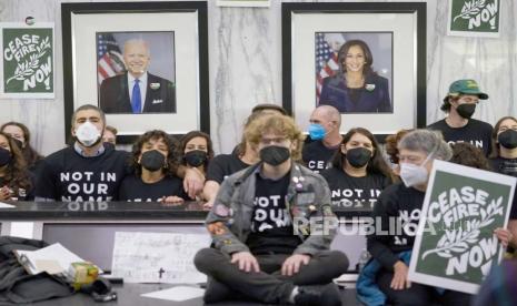 Potret Presiden Joe Biden dan Wakil Presiden Kamala Harris terlihat di dalam gedung federal ketika demonstran menuntut gencatan senjata di Gaza di Oakland, Kalifornia, AS, Senin, 13 November 2023.