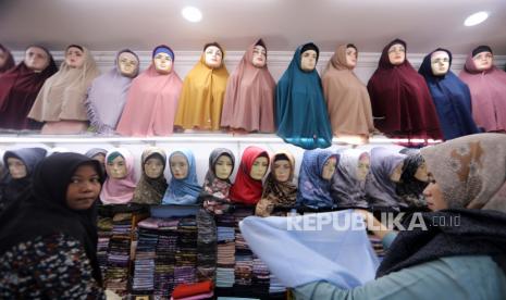  Pakaian muslim dipajang di pasar tradisional di pasar Aceh, Banda Aceh, 25 April 2022. Transaksi jual beli tekstil khususnya pakaian muslim meningkat sangat pesat tahun ini menyusul kondisi pandemi Covid-19 yang landai dan persiapan masyarakat menjelang Ramadhan dan Idul Fitri. Berdasarkan data State of Global Islamic Economy Report 2020/2021, tren belanja busana muslim di Indonesia diprediksi akan meningkat pesat hingga tahun 2024 mencapai 4,5 triliun rupiah. Pengeluaran Muslim Global Capai Rp 29 Kuadriliun pada 2021