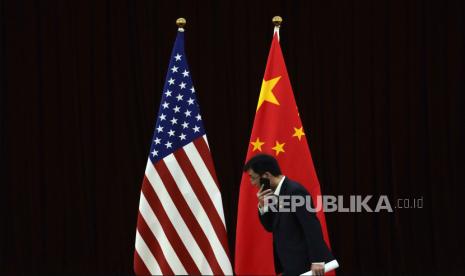 Pejabat China berjalan melewati bendera nasional AS dan China menjelang pertemuan bilateral antara Menteri Keuangan AS Janet Yellen dan Wakil Perdana Menteri China He Lifeng, di Guangdong Zhudao. 