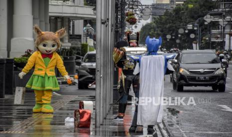 Cosplayer menghibur pengunjung di Kawasan Asia Afrika, Kota Bandung, Jumat (19/11). Pemerintah menetapkan seluruh wilayah di Indonesia berstatus Pemberlakuan Pembatasan Kegiatan Masyarakat (PPKM) Level 3 saat momen libur Natal dan Tahun Baru (nataru) yang berlangsung mulai 24 Desember 2021 hingga 2 Januari 2022. Hal tersebut dilakukan guna mengantisipasi gelombang ketiga lonjakan kasus Covid-19.