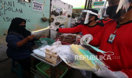 Satgas Kampung Tangguh membagikan alat pelindung wajah (face shield) kepada pedagang di Pasar Keputih, Surabaya, Jawa Timur. Pemkot Surabaya melibatkan Satgas Kampung selama mudik Lebaran.