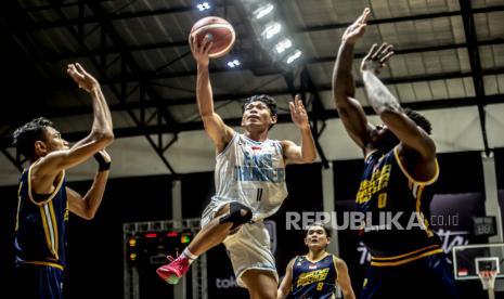 Pebasket Evos Thunder Bogor Muhammad Yassier Rahmat (tengah) melakukan lay up dengan dihalangi pebasket Satya Wacana Salatiga Tyree Jamal Robinson (kanan) dan Randy Ady Prasetya (kiri) dalam pertandingan Seri 1 Jakarta Indonesian Basketball League (IBL) 2022 di Hall Basket Senayan, kompleks Stadion Utama Gelora Bung Karno (SUGBK), Jakarta, Sabtu (22/1/2022). Satya Wacana Salatiga mengalahkan Evos Thunder Bogor dengan skor 69-54.