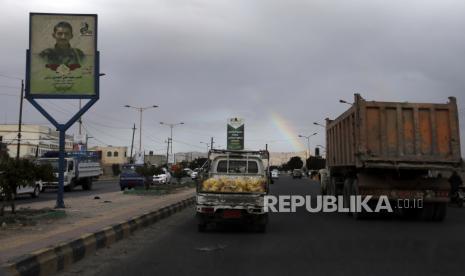  Kendaraan melewati spanduk yang menggambarkan potret pejuang Houthi yang diduga tewas dalam perang yang sedang berlangsung di Yaman, di sebuah jalan di Sana