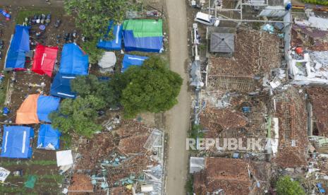 Sejumlah posko pengungsian warga berdiri di dekat rumah yang hancur akibat gempa bumi di Garogol Kidul, Cibulakan, Cugenang, Kabupaten Cianjur, Jawa Barat, Jumat (25/11/2022). Masa tanggap darurat penanganan gempa bumi di Kabupaten Cianjur ditetapkan selama 30 hari sejak Senin (21/11/2022). 