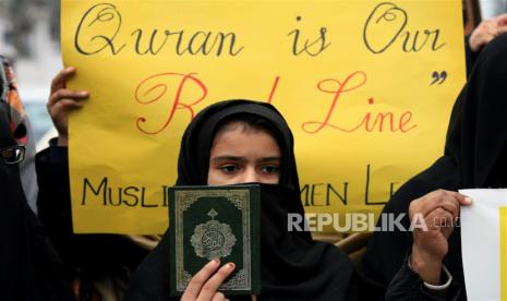  Seorang pendukung partai Liga Wanita Muslim mengangkat salinan Alquran selama protes terhadap Swedia, di Peshawar, Pakistan, Sabtu (28/1/2023). Norwegia Batalkan Pembakaran Alquran Setelah Melihat Reaksi Turki