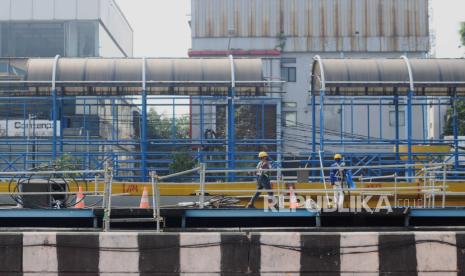 Petugas berjalan di dekat konstruksi Jembatan Penyeberangan Orang (JPO) yang sedang dalam tahap pembongkaran di Jalan Gajah Mada, Jakarta Pusat, Jumat (26/5/2023). Sebanyak empat JPO yang menghubungi Jalan Gajah Mada dan Jalan Hayam Wuruk dibongkar untuk persiapan pembangunan konstruksi MRT Jakarta CP202. JPO yang dibongkar yaitu, JPO Harmoni yang berada di depan Duta Merlin, JPO Harmoni di depan Bapeten, JPO Sawah Besar dan JPO Mangga Besar.