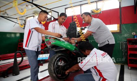 Siswa dengan didampingi gurunya mengecek kondisi motor listrik sebelum diuji coba di SMKN 1 Nglegok, Blitar, Jawa Timur, Rabu (1/2/2023). 