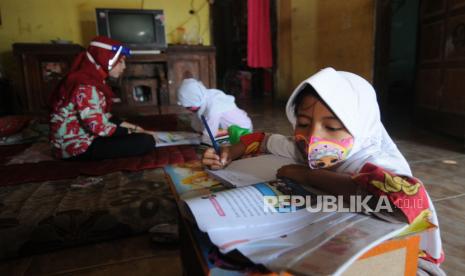 Guru SDN 2 Guli mengajar dua siswa kelas satu di rumah siswanya yang terkendala belajar daring di Guli, Nogosari, Boyolali, Jawa Tengah, Kamis (23/7/2020).  Program Organisasi Penggerak yang digagas Kemendikbud untuk meningkatkan kompetensi guru dan kepala sekolah menjadi polemik karena dianggap tidak transparan.