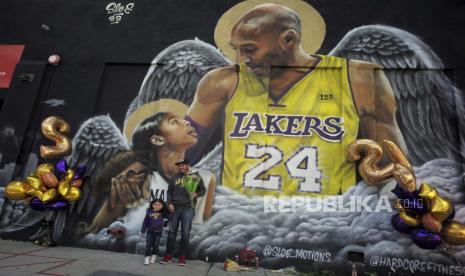  Jose Jara bersama putrinya yang berusia tiga tahun Giana berpose di depan mural di sisi Hardcore Fitness bersama Pico Blvd saat penggemar Kobe Bryant merayakan kehidupan dan warisan seputar mural dan tugu peringatan darurat di Los Angeles pada hari Selasa, Jan 26, 2021.