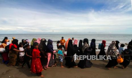 Sejumlah etnis Rohingya berjalan menunju tempat istirahat setelah dievakuasi warga di Desa Bluka Teubai, Kecamatan Dewantara, Aceh Utara, Aceh, Rabu (16/11/2022). Sebanyak 119 imigran etnis Rohingya, terdiri dari 61 orang laki-laki, 37 orang perempuan, dan 22 anak-anak terdampar di pesisir laut Dewantara pukul 05.00 WIB pada Rabu (16/11/) dini hari, pasca satu hari sebelumnya sebanyak 110 orang etnis Rohingya terdampar di pesisir Krueng Mane Aceh Utara, Aceh. Muslim Rohingya, Terjebak Antara Junta Militer Myanmar dan Tentara Arakan