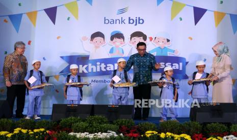 Gubernur Jawa Barat Ridwan Kamil (tengah) dan Direktur Utama Bank BJB Yuddy Renaldi (kiri) berfoto bersama sejumlah anak peserta Khitanan Massal Bank BJB di Kantor Pusat Bank BJB, Jalan Naripan, Kota Bandung, Rabu (4/1/2023). 