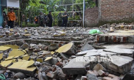 Bupati Tasikmalaya Ade Sugianto (kanan) meninjau rumah warga yang roboh akibat terdampak gempa di Desa Singajaya, Kecamatan Cibalong, Kabupaten Tasikmalaya, Jawa Barat, Ahad (28/4/2024). Berdasarkan data dari BPBD Kabupaten Tasikmalaya sebanyak 19 rumah dan empat fasilitas umum di 12 kecamatan mengalami kerusakan akibat terdampak gempa bumi magnitudo 6.5 di Barat Daya Garut.