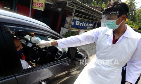 Petugas kesehatan memeriksa suhu tubuh penumpang kendaraan di chek point Jalan Nanggulan-Mendut, Kulon Progo, Yogyakarta, Ahad (17/5). Pemeriksaan kendaraan dengan plat nomor luar Jogja ini untuk memantau pendatang saat pandemi virus corona