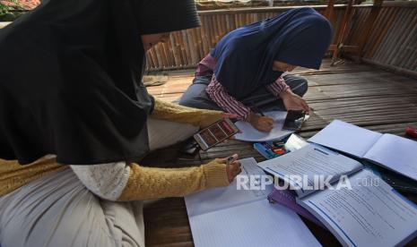 Siswa mengerjakan soal matematika saat mengikuti pembelajaran dalam jaringan (daring) di Komplek Perumahan Makmur Jaya, Drangong, Serang, Banten, Selasa (4/8/2020). Sekumpulan warga setempat yang terhimpun dalam Komunitas Digital Serang (KDS) bekerja sama dengan pengurus lingkungan menyediakan akses internet gratis guna membantu para pelajar dari keluarga kurang mampu mengikuti pembelajaran secara daring. 