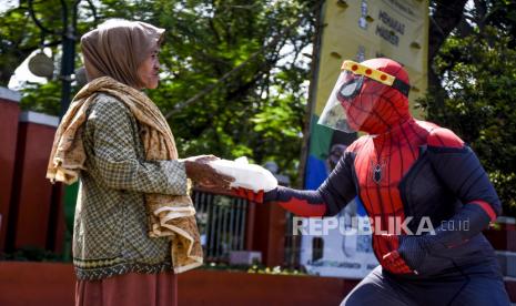 Anggota Badut Nyentrik Cimahi Bandung Sauyunan (Necis) membagikan makanan gratis kepada warga di kawasan Alun-alun Cimahi, Kota Cimahi, Jumat (28/8). Komunitas Badut Necis membagikan sedikitnya 75 porsi makanan gratis kepada warga yang membutuhkan sebagai bentuk kepedulian terhadap sesama di masa pandemi Covid-19. Foto: Abdan Syakura/Republika