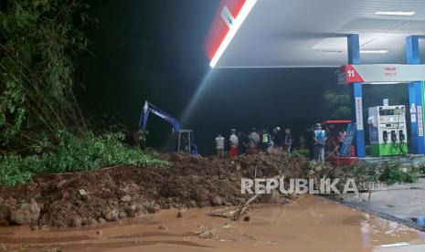 Petugas membersihkan material longsor yang menutup akses keluar kendaraan besar dan sebagian area pengisian BBM di SPBU rest Area KM 429 A ruas tol Semarang- Solo, Selasa (31/1) sore.