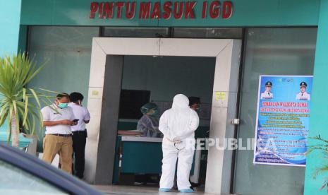 Petugas medis berpakain alat pelindung diri berjaga di depan pintu masuk instalasi gawat darurat Rumah Sakit Umum (RSUD). Ilustrasi