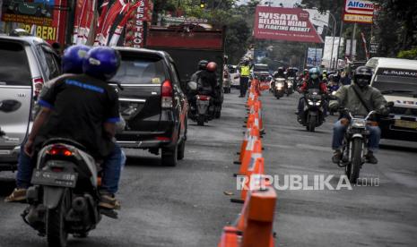 Petugas kepolisian mengatur lalu lintas di Jalan Raya Lembang, Kabupaten Bandung Barat, Kamis (20/8). Kemacetan tersebut disebabkan penumpukan kendaraan wisatawan baik dalam maupun luar Kota Bandung yang akan mengunjungi dan pulang dari kawasan wisata di Lembang. Foto: Abdan Syakura/Republika