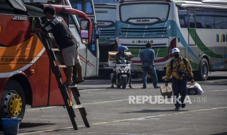 Calon penumpang berjalan menuju bus mudik.