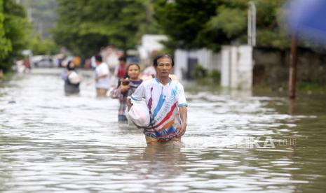 Sejumlah warga melewati jalan yang tergenang banjir di Kota Gorontalo, Gorontalo, Kamis (11/7/2024). BPBD Kota Gorontalo mendata sebanyak 1.669 KK atau mencapai 12.487 jiwa terdampak banjir yang menggenangi Kecamatan Kota Selatan, Hulonthalangi, Dumbo Raya, Kota Barat, Kota Timur, dan Dungingi akibat luapan sungai Bulango dan Bone. 