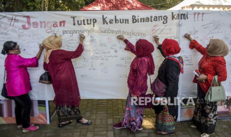 Sejumlah warga mengenakan kebaya membubuhkan tanda tangan sebagai bentuk dukungan saat Bandung Lautan Kebaya di Bandung Zoological Garden, Kota Bandung, Senin (8/8/2022). Bandung Lautan Kebaya yang diikuti oleh sedikitnya 35 komunitas dari berbagai daerah tersebut digelar dalam rangka pelestarian kebaya sebagai warisan leluhur dan upaya mendaftarkan kebaya ke UNESCO sebagai warisan budaya tak benda asal Indonesia. Selain itu, kegiatan tersebut sebagai upaya dukungan penyelesaian atas polemik kepemilikan lahan kebun binatang bandung (Bandung Zoological Garden). Republika/Abdan Syakura