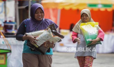 Warga membawa beras saat bazar pasar murah di Kantor Kecamatan Pancoran, Jakarta, Senin (26/2/2024). Bazar pasar murah yang menjual kebutuhan pokok seperti beras SPHP Rp 53.000, beras permium Rp 69.500, tepung terigu Rp 12.000 dan minyak goreng kita Rp 17.000 itu untuk membantu masyarakat mendapatkan barang kebutuhan pokok dengan harga terjangkau terutama beras yang mengalami kenaikan harga.