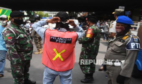 Seorang warga yang terjaring razia penindakan pelanggaran aturan Pembatasan Sosial Berskala Besar (PSBB) oleh Satpol PP (ilustrasi)