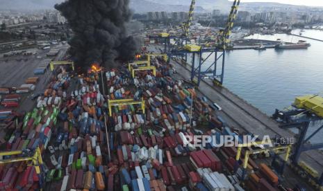 Api melalap tumpukan peti kemas di Pelabuhan Iskenderun, Provinsi Hatay, Turki Selasa (7/2/2023). Gempa membuat tumpukan berjatuhan dan menimbulkan kebakaran hebat. (AP/Hussein Malla)