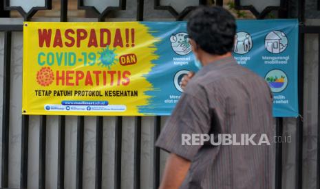 Spanduk himbauan waspada terhadap Covid-19 dan Hepatitis terpasang di depan Madrasah Muallimat, Yogyakarta, Jumat (20/5/2022). Pemerintah Kota (Pemkot) Yogyakarta meminta warga untuk tetap menggunakan masker meskipun di area terbuka. Hal ini untuk menjaga agar tidak terjangkit hepatitis akut yang menyerang anak-anak seperti yang sudah terjadi di DKI Jakarta.