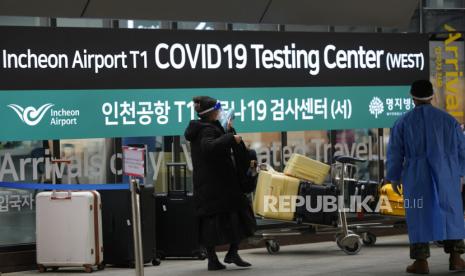  FILE - Seorang wanita yang tiba dari China memasuki pusat pengujian COVID-19 di Bandara Internasional Incheon Di Incheon, Korea Selatan, Kamis, 5 Januari 2023. China menangguhkan visa pada Selasa bagi warga Korea Selatan yang datang ke negara tersebut untuk pariwisata atau bisnis di pembalasan nyata untuk persyaratan pengujian COVID-19 pada pelancong China.